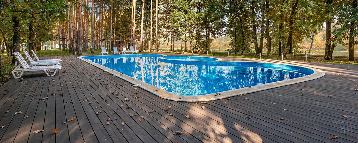 A wooden custom deck surrounding a pool - Read more about our other projects on our blog